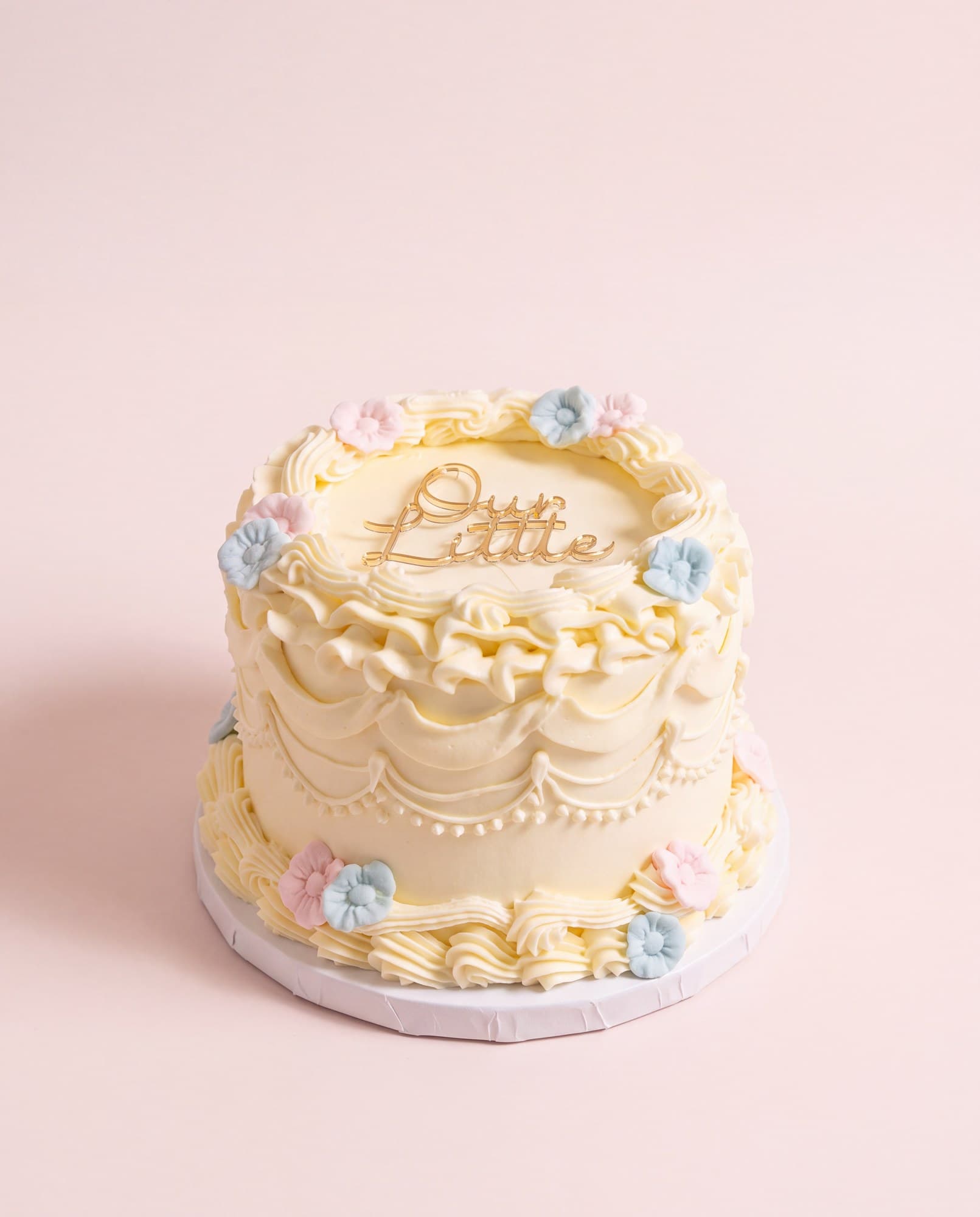Ivory mini cake with piped swags and pastel flowers